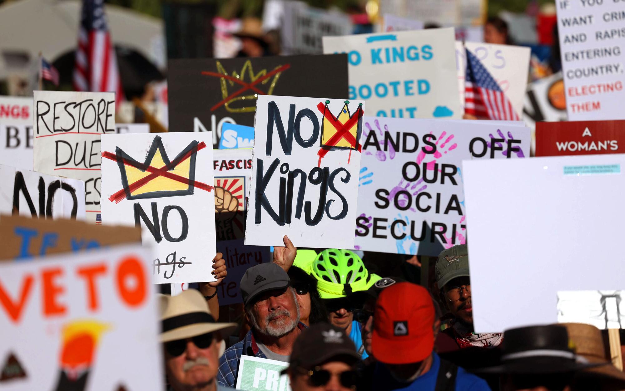 People march with signs during the nationwide "No Kings" protest in downtown Tucson, Ariz., on Saturday, Oct. 18, 2025. (Grace Trejo/Arizona Daily Star via AP)