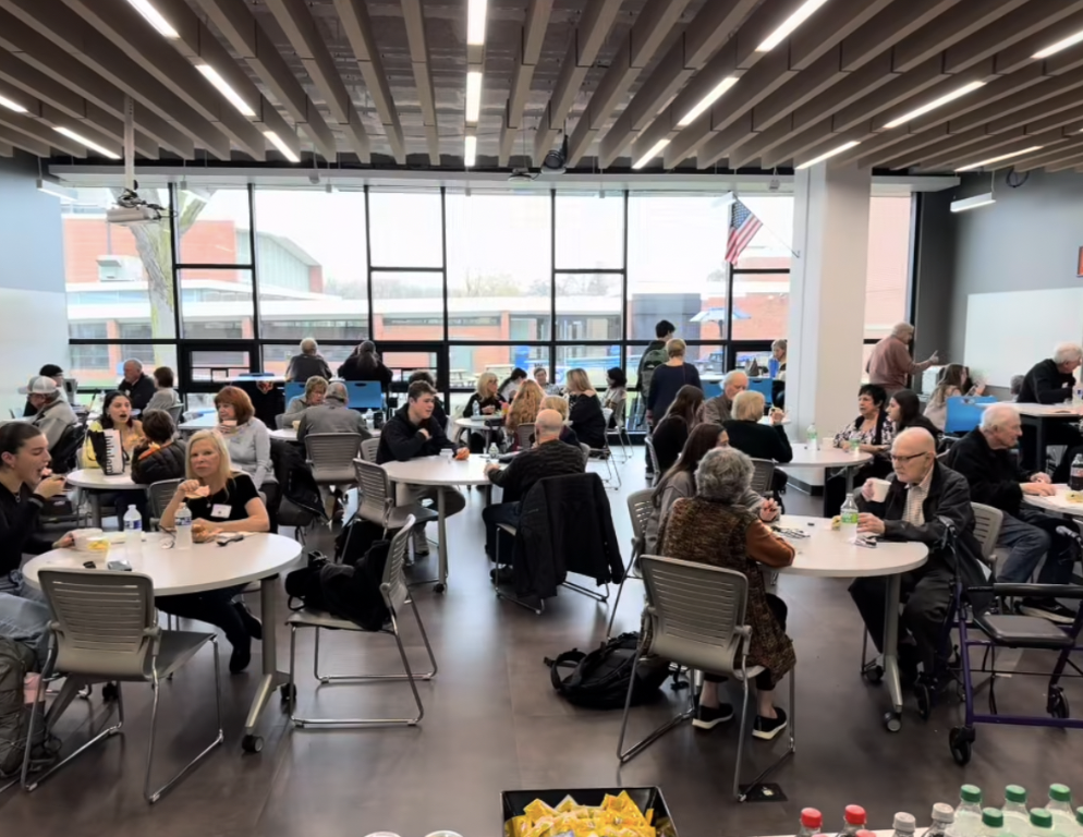 HP students eat lunch with their grandparents in the library.